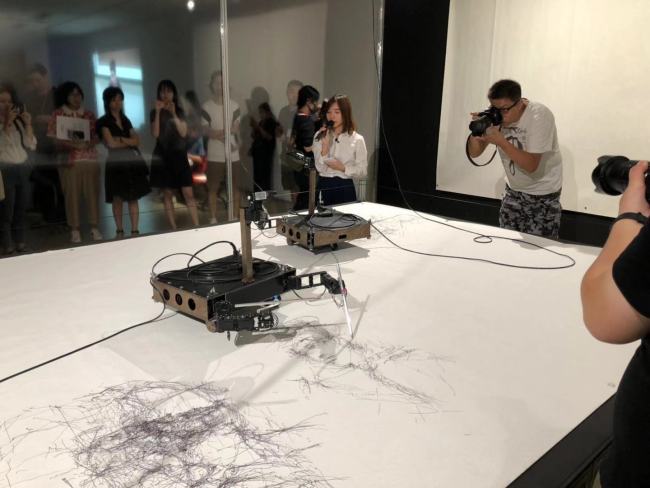 Two image-drawing robots are operating at an exhibition as part of a Future Gallery project which began in Beijing on Monday, Aug 19, 2019. [Photo: China Plus]