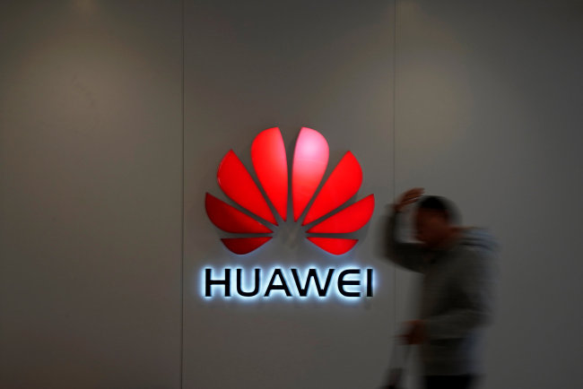 A man walks by a Huawei logo at a shopping mall in Shanghai, China December 6, 2018. [File photo: Reuters via VCG/Aly Song]