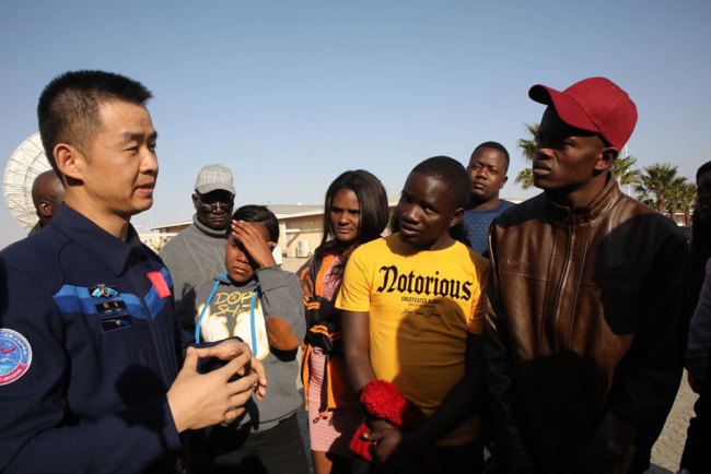 Visiting Chinese astronaut Chen Dong interacts with local students at Namibia's Space TT&C Station in Swakopmund on Monday, August 19, 2019. [Photo: China Plus]