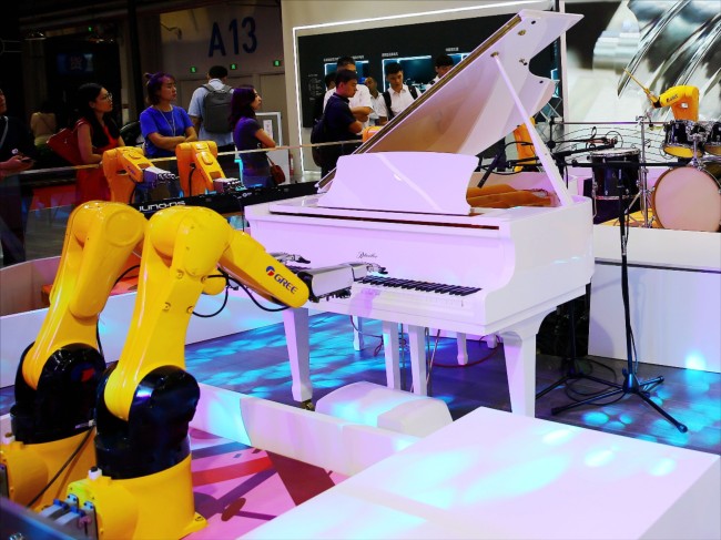 Robotic arms produce by the Chinese appliance maker Gree play the piano at the 2019 World Robot Conference at the Etrong International Exhibition & Convention Center in Beijing on Tuesday, August 20, 2019. [Photo: IC]