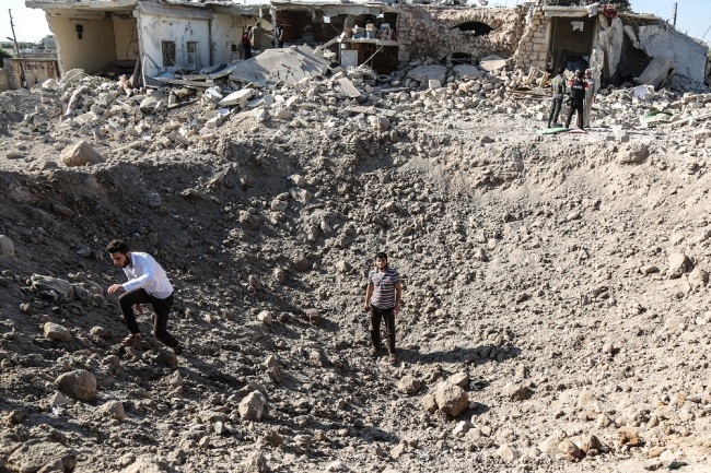 People inspect the damage following a reported air strike in the area of Tallmannis in Syria's northern Idlib province, Syria, August 22, 2019. [Photo: DPA via IC/Anas Alkharboutli]