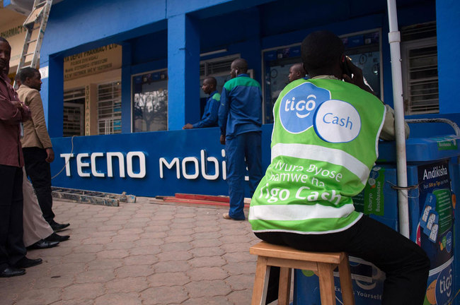 Workers prepare to hoist a Tecno Mobile sign above a new phone retail store ahead of opening in Kigali, Rwanda, on Wednesday, Sept. 18, 2013. [Photo: VCG]