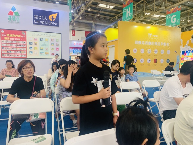 A girl reader asks a question to Lion Cub author Liu Hu during a book promoting engagement. [Photo provided to China Plus]