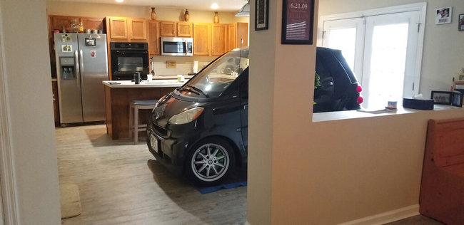 In this Sept. 3, 2019 photo made available by Jessica Eldridge shows her husband's Smart car parked in their kitchen in Jacksonville, Fla. Patrick Eldridge parked his Smart car in his kitchen to protect it from Hurricane Dorian. In a Facebook post, Jessica Eldridge said her husband was "afraid his car might blow away" so he parked it in their Jacksonville home's kitchen.[Photo: AP] 