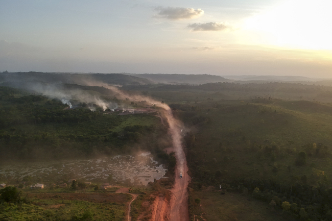 In this aerial view the red dust of the BR230 highway, known as "Transamazonica", mixes with fires at sunset in the agriculture town of Ruropolis, Para state, northen Brazil, on September 6, 2019. [Photo: AFP/Johannes MYBURGH] 