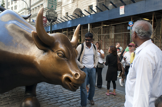 The Charging Bull Statue surrounded by tourists in the Financial District, near the New York Stock Exchange in Manhattan. [Photo: IC]