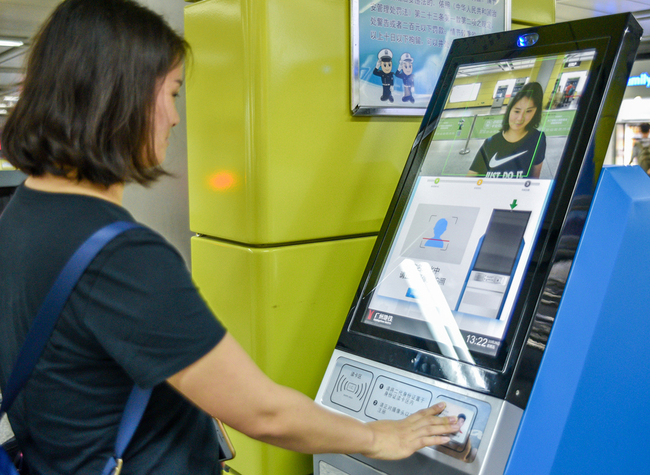 A woman registering with a facial recognition scanner using her ID card at a subway station in Guangzhou, Guangdong Province, on October 26, 2018. [File Photo: VCG]