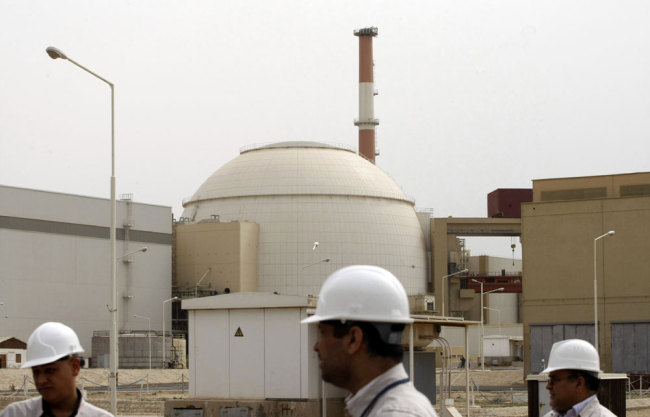 In this file photo taken on February 25, 2009, Iranian technicians walk outside the building housing the reactor of Bushehr nuclear power plant at the Iranian port town of Bushehr, 1200 Kms south of the capital Tehran. [File photo: AFP/Behrouz Mehri]