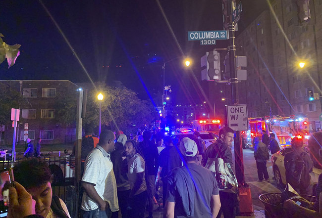 In this photo provided by Peter Sacco, a crowd gathers at a cordoned-off intersection near a shooting Thursday, Sept. 19, 2019, in a Washington D.C. neighborhood. [Photo: Peter Sacco via AP]