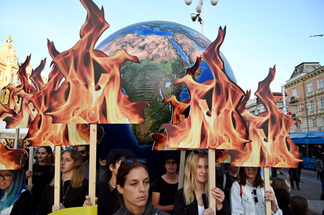 Students and activists hold up a globe as they take part during the Global Climate Strike march downtown Zagreb, Croatia, on September 20, 2019. [Photo: AFP/Denis Lovrovic]