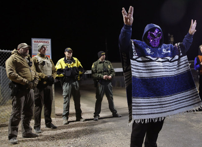 A man in an alien mask stands at an entrance to the Nevada Test and Training Range near Area 51 Friday, Sept. 20, 2019, outside of Rachel, Nev. People gathered at the gate inspired by the "Storm Area 51" internet hoax. [Photo: AP/John Locher]