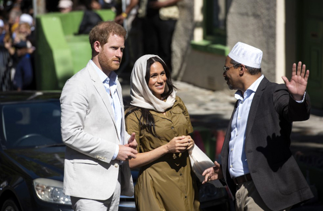 Prince Harry (L), Duke of Sussex and Meghan Duchess of Sussex (C) visit the oldest mosque of Cape Town in Dorp Street in Bo Kaap district on September 24, 2019. [Photo: AFP/David Harrison]
