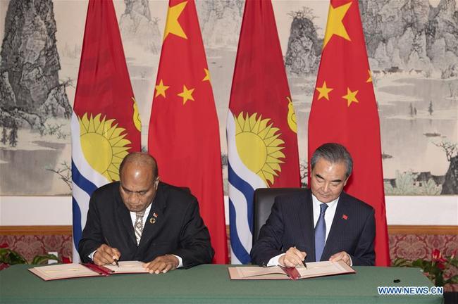 Chinese State Councilor and Foreign Minister Wang Yi (R) and Kiribati's President Taneti Mamau sign documents to restore diplomatic relations between the two countries at the Chinese Permanent Mission to the United Nations in New York, on Sept. 27, 2019. [Photo: Xinhua/Liu Jie]