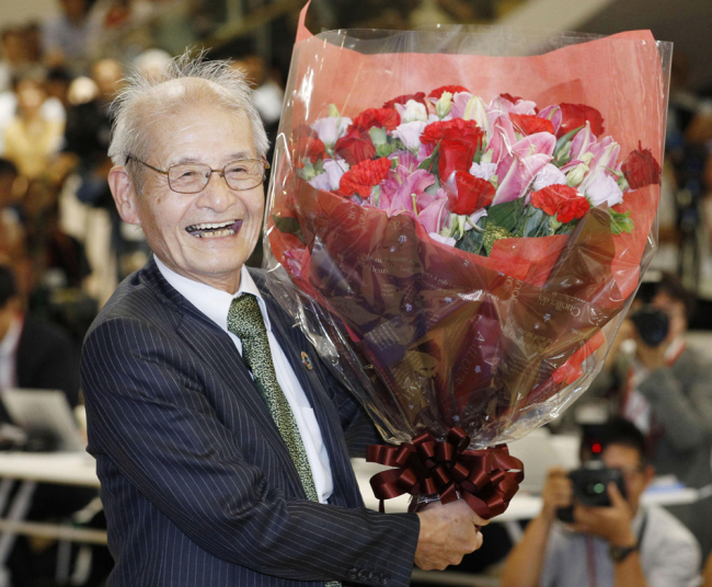 Akira Yoshino of Asahi Kasei Corporation poses with a bouquet of flowers in Tokyo Wednesday, Oct. 9, 2019, following an announcement that he was awarded the Nobel Prize in Chemistry. [Photo: Kyodo News via AP/Yuta Omori]