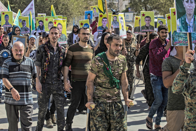 Fighters and veterans from the Kurdish women's protection units (YPJ) and the people's protection units (YPG) march in front of the UN headquarters in the northern Kurdish Syrian city of Qamishli during a protest against Turkish threats in the Kurdish region, on October 8, 2019. [Photo: AFP/Delil Souleiman]