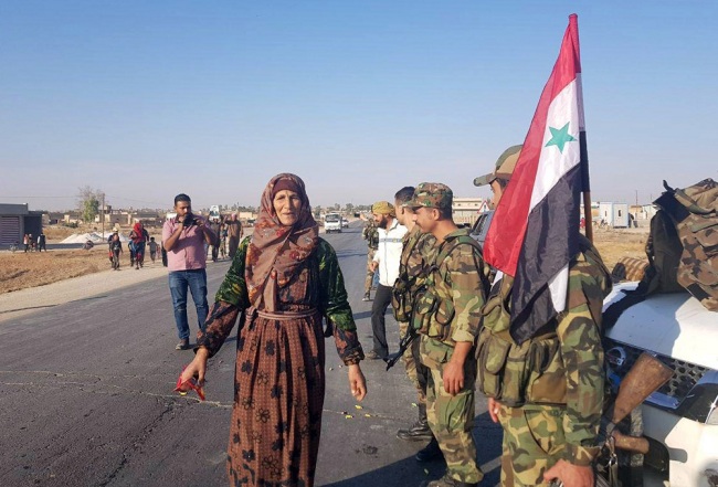 A handout photo made available by the official Syrian Arab News Agency (SANA) shows civilians welcoming Syrian army soldiers arriving at Tal Tamr town, in the northwestern Hasaka, Syria, October 14, 2019. [Photo:EPA/IC]