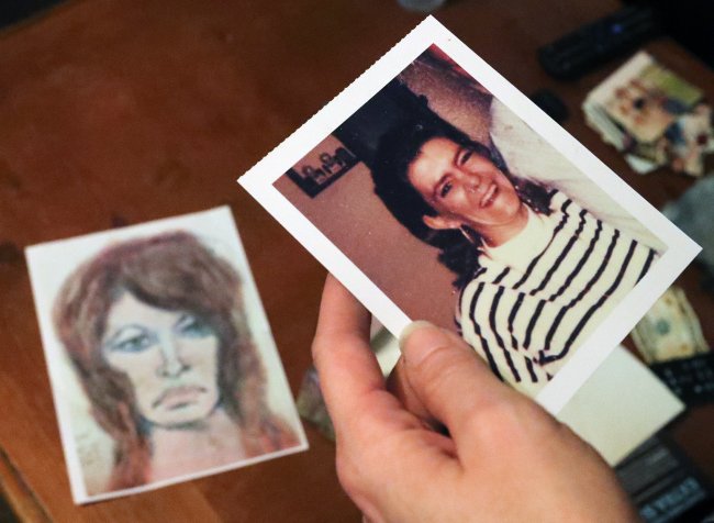 Tonya Maslar holds an old photograph of her mother Roberta Tandarich taken before her death in 1991 in Ravenna, Ohio on Oct. 10, 2019. Tandarich's body was found dumped at Firestone Metro Park in 1991. A sketch of Tandarich drawn by serial killer Samuel Little, who claims Tandarich was one of his many victims, lies in the background.  [Photo: Akron Beacon Journal via AP/Jeff Lange]