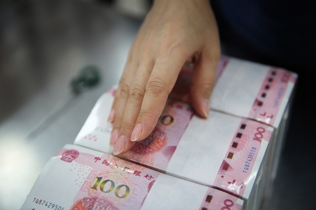 A Chinese worker checks packed RMB (renminbi) yuan notes at a factory of Shijiazhuang Banknote Printing of China Banknote Printing and Minting Corporation (CBPMC) in Shijiazhuang City, north China's Hebei Province, April 20, 2017. [File Photo: IC]