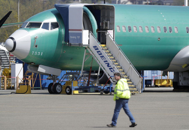 In this April 26, 2019, file photo a worker walks past a Boeing 737 MAX 8 airplane being built for Oman Air at Boeing's assembly facility in Renton, Wash. [Photo: AP]