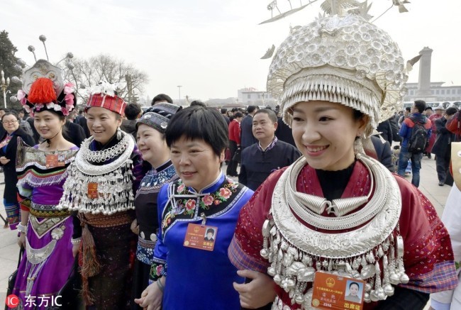 Delegates representing China's ethnic minority groups smile before entering the Great Hall of the People in Beijing on March 5, 2018, to attend the annual session of the National People's Congress. [File Photo: IC]