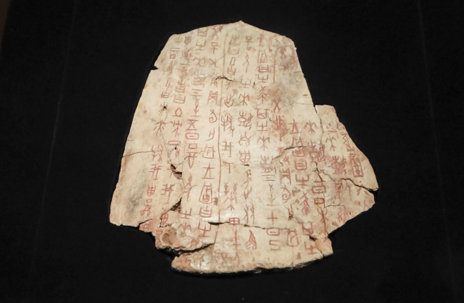 An oracle bone artifact is on display at an exhibition held in the National Museum in Beijing, China. [Photo: VCG]