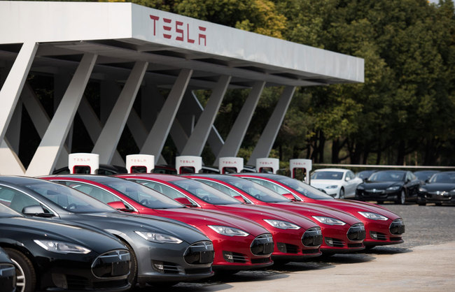 This picture taken on March 17, 2015 shows Tesla Model S vehicles parked outside a car dealership in Shanghai. [Photo: AFP]