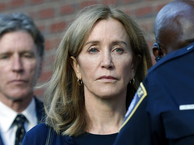 In this Sept. 13, 2019 file photo, actress Felicity Huffman leaves federal court in Boston with her brother Moore Huffman Jr., left, after she was sentenced in a nationwide college admissions bribery scandal. [Photo: AP]