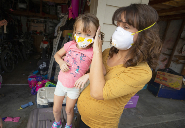 Remington, 4, and Lauren Irwin pack up their home in Healdsburg, California, after officials ordered an evacuation, Saturday, Oct. 26, 2019. [Photo: The Press Democrat via AP/John Burgess]