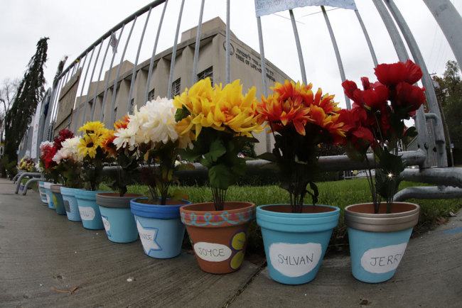 Flower pots, each with a name of one of the 11 worshipper killed on Oct. 27, 2018 when a gunman opened fire as worship services began at the Tree of Life Synagogue in the Squirrel Hill neighborhood of Pittsburgh, line the fence surrounding the Tree of Life Synagogue on Saturday, Oct. 26, 2019 in Pittsburgh. The first anniversary of the shooting at the synagogue, that killed 11 worshippers, is Sunday, Oct., 27, 2019. [Photo: AP via IC/Gene J. Puskar]