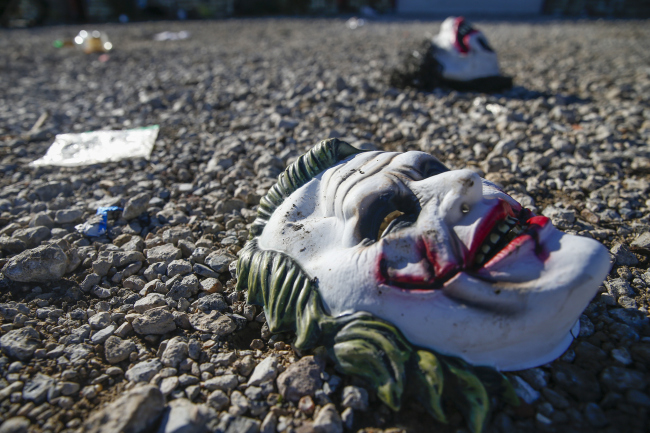Halloween masks litter the ground amongst signs of chaos at the scene where a deadly shooting in Greenville, Texas, Sunday, Oct. 27, 2019. [Photo: Ryan Michalesko/The Dallas Morning News via AP]