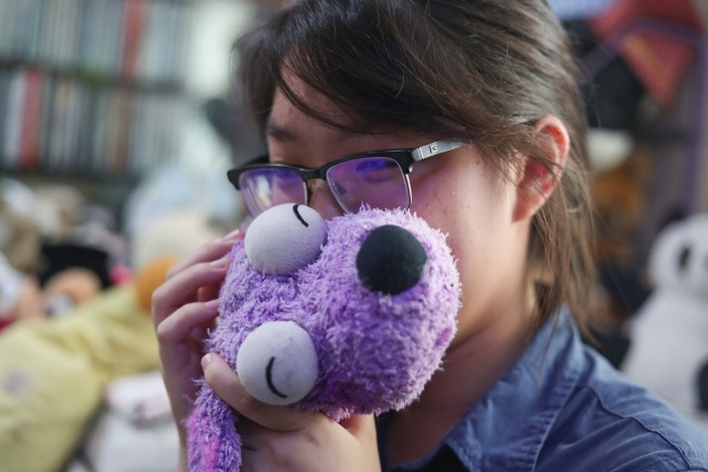A young woman has a moment with her toy before leaving it at the toy hospital in Shanghai. [Photo: IC]
