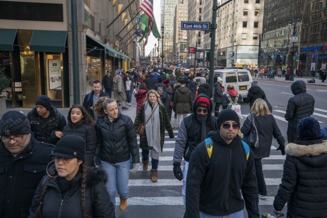 Shoppers and pedestrians walk past stores on Fifth Avenue on Black Friday November 23, 2018 in New York. [Photo: AFP/ Don EMMERT] 