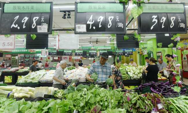Customers picking up vegetable at a supermarket in Hangzhou, Zhejiang Province, on July 10, 2019. [File photo: IC]