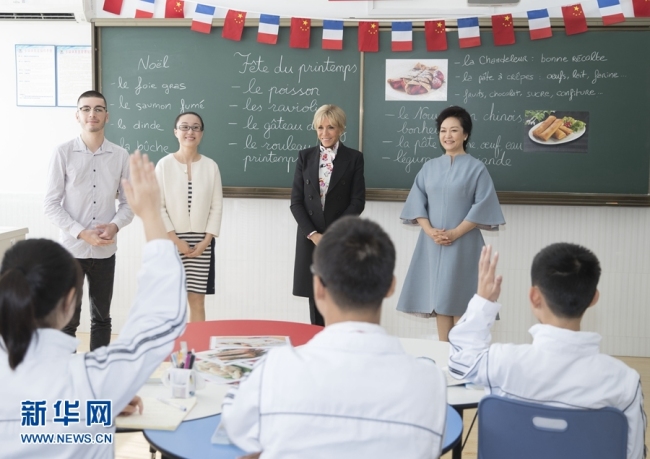 Peng Liyuan, wife of Chinese President Xi Jinping and Brigitte Macron, wife of French President Emmanuel Macron visit a local middle school in Shanghai on Tuesday, November 05, 2019. [Photo: Xinhua]
