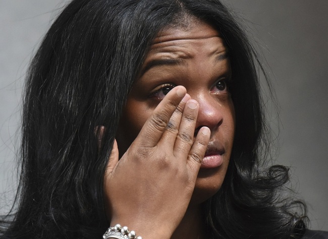 Ashley Smith wipes away tears as others talk about how she and others were mistreated recently at a Naperville, Ill. Buffalo Wild Wings restaurant. [Photo: Paul Valade/Daily Herald via AP]