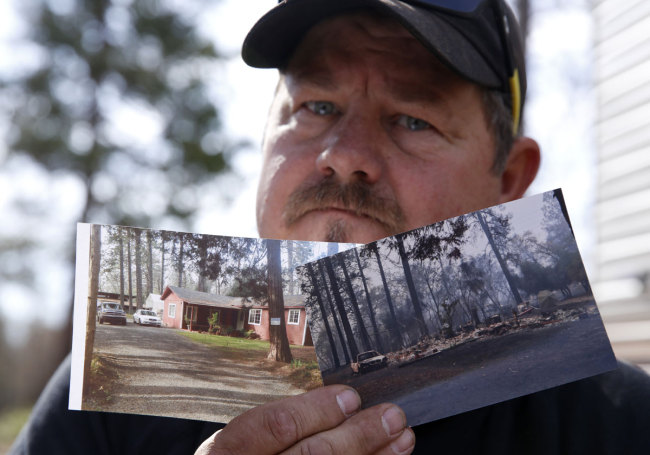 In this Thursday Oct. 24, 2019, photo, Bill Husa displays before-and-after photos of his home lost in last year's Camp Fire in Paradise, Calif. [Photo: AP]