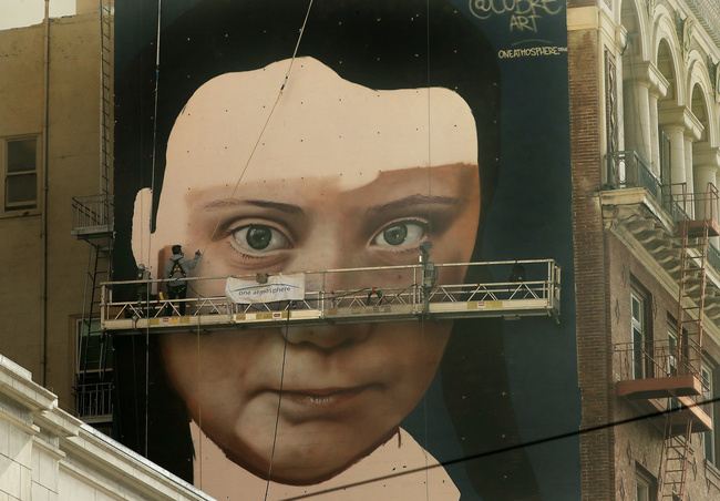 Andres Petreselli paints a mural on the side of a building depicting Swedish teen climate activist Greta Thunberg, Friday, Nov. 8, 2019, in San Francisco. [Photo: AP]