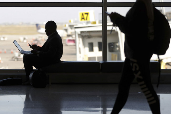 In this Wednesday, Nov. 21, 2018 file photo, travelers check their phones at Indianapolis International Airport in Indianapolis. [Photo: AP]