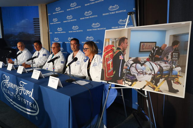 A photo of a patient being transported is displayed while medical staff at Henry Ford Hospital answer questions during a news conference in Detroit, Tuesday, Nov. 12, 2019. A Henry Ford Health System medical team performed a double lung transplant, for the unidentified patient in the photograph, whose lungs were irreparably damaged from vaping. [Photo: AP/Paul Sancya]