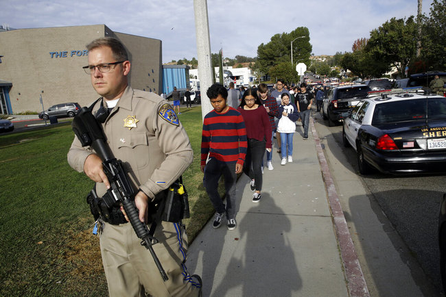 This Nov. 14, 2019 file photo shows a California Highway Patrol officer escorting students out of Saugus High School after a shooting on the campus in Santa Clarita, Calif. [File photo: AP]