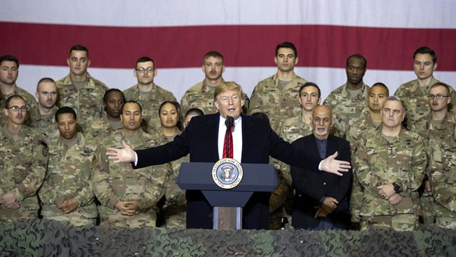 U.S. President Donald Trump, center, with Afghan President Ashraf Ghani and Joint Chiefs Chairman Gen. Mark Milley, behind him at right, while addressing members of the military during a surprise Thanksgiving Day visit, Nov. 28, 2019, at Bagram Air Field, Afghanistan. [Photo: AP/Alex Brandon]