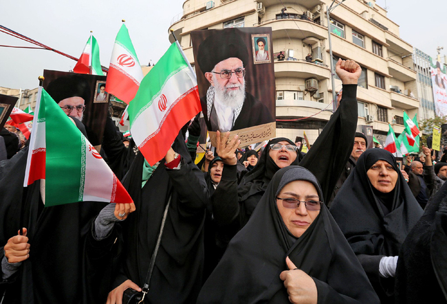 Iranian women holding national flags and pictures of the Islamic republic's supreme leader, Ayatollah Ali Khamenei, take part a pro-government demonstration in the capital Tehran's central Enghelab Square on November 25, 2019. [Photo: VCG]