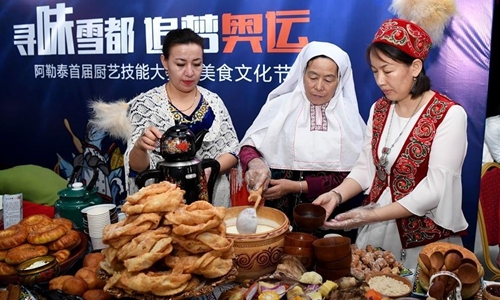 Women of Kazakh ethnic group show their traditional food in Altay, northwest China's Xinjiang Uygur Autonomous Region, Nov. 27, 2019. The 14th Xinjiang Winter Tourism Trade Fair opened here on Wednesday. [Photo: Xinhua/Sadat]
