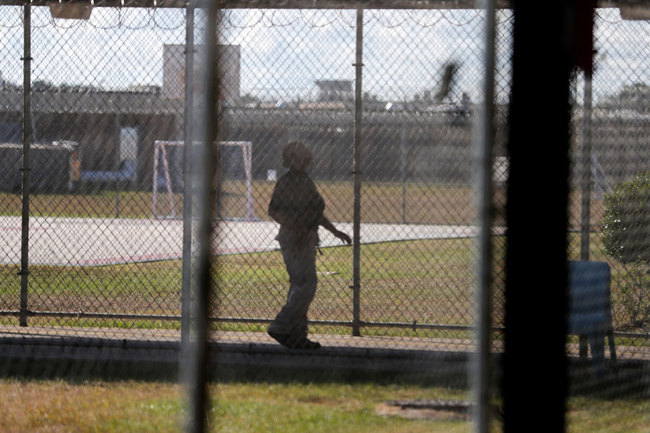 In a Thursday, Sept. 26, 2019 file photo, a guard walks on a path between yards during a media tour inside the Winn Correctional Center in Winnfield, La.[File Photo: AP/Gerald Herbert]