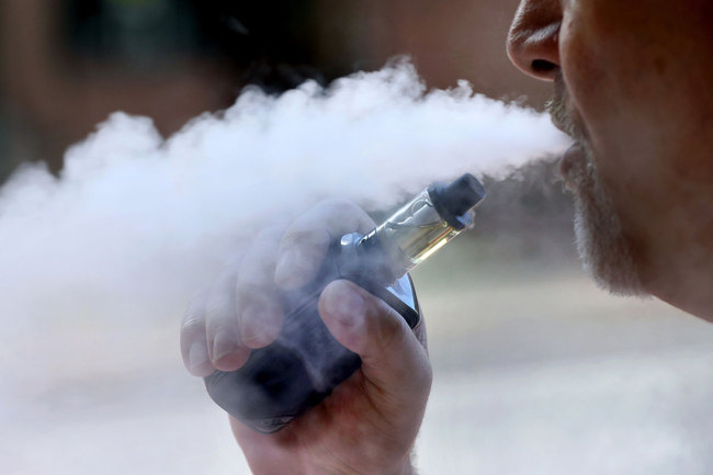 In this Aug. 28, 2019, file photo, a man exhales while smoking an e-cigarette in Portland, Maine. [Photo: AP]