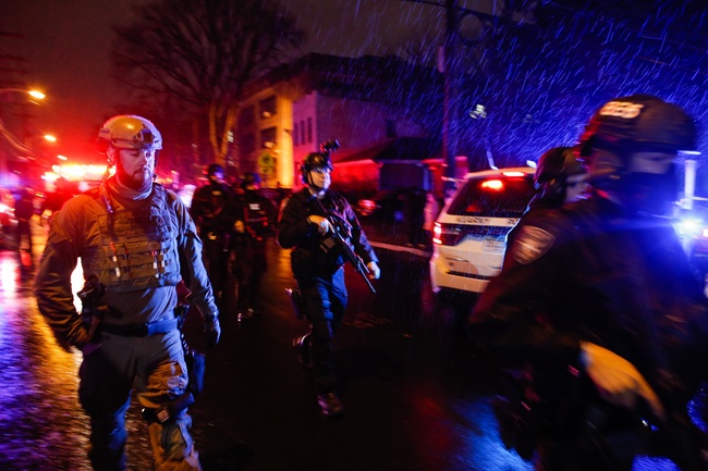 Law enforcement personnel walk near the scene following a shooting, Tuesday, Dec. 10, 2019, in Jersey City, N.J. [Photo: AP/Eduardo Munoz Alvarez]