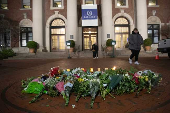 A woman walks past a make-shift memorial for Tessa Majors inside the Barnard College campus, Thursday, Dec. 12, 2019, in New York. Majors, a 18-year-old Barnard College freshman from Virginia, was fatally stabbed in a park near the school's campus in New York City. [Photo: AP/Mary Altaffer]