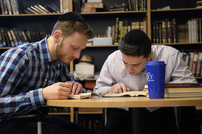 Yeshiva University students Aaron Heideman, left, and Marc Shapiro study in the university's library in New York, Thursday, Dec. 12, 2019. [Photo: AP]