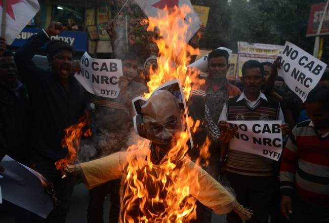 Indian left wing activists of Democratic Youth Federation of India (DYFI) shout slogans as they burn an effigy of India's Home Minister Amit Shah during a demonstration against the Indian government's Citizenship Amendment Bill in Siliguri on December 14, 2019. [Photo: AFP/ DIPTENDU DUTTA]