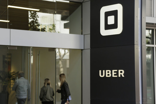 In this June 21, 2017, file photo, people make their way into the building that houses the headquarters of Uber in San Francisco. [Photo: AP]